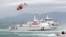 FILE - Taiwan Coast Guard ships and a helicopter take part in a drill at a harbor in New Taipei City, Taiwan, May 4, 2019.