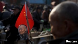 FILE - A retired worker watches a Chinese opera performance that Xinyuan Steel put on to mark the end of Chinese New Year festivities in Anyang, Henan province, China, Feb. 19, 2019.