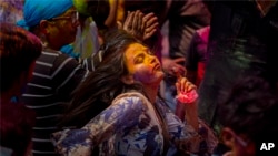 Indians dance and throw colored powder during Holi festival celebrations that heralds the arrival of spring, Gauhati, India, March 10, 2020. 