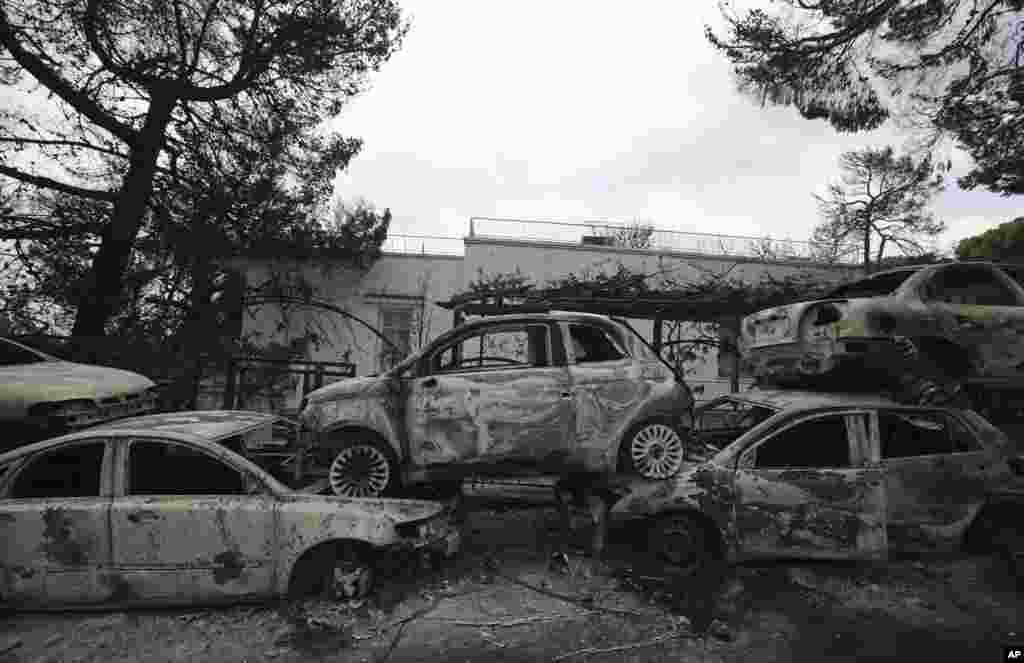 Burned-out cars are strewn along the roadside in Mati east of Athens, Tuesday, July 24, 2018.