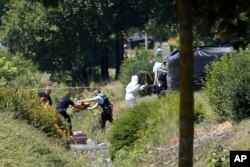 Investigating police officers work outside the U.S.-based plant where an attack took place in Saint-Quentin-Fallavier, southeast of Lyon, France, June 26, 2015.