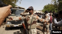 FILE - A Pakistan Ranger gestures to stop members of the media from taking pictures at an anti-terrorism court in Karachi, Pakistan, March 12, 2015.