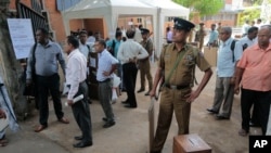 Sri Lankan election workers wait to leave for their respective voting centers after collecting polling material from a distribution center in Colombo, Sri Lanka, Sunday, Aug. 16, 2015.