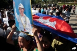FILE - A supporter of the opposition Cambodia National Rescue Party holds a portrait of the party leader Kem Sokha during a rally in Phnom Penh, Cambodia, Sept. 26, 2017.