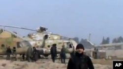 In this image taken from video obtained from the Ugarit News, which has been authenticated based on its contents and other AP reporting, Syrian rebels capture a helicopter air base near the capital Damascus after fierce fighting in Syria, on Sunday, Nov.