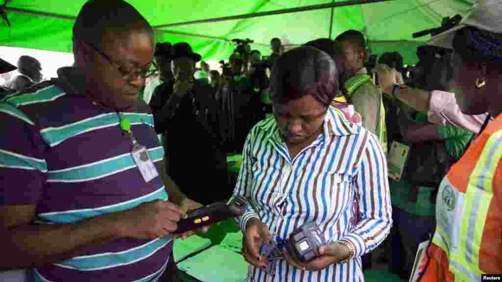 Officials of the Independent National Electoral Commission troubleshoot card readers after they failed to capture President Goodluck Jonathan&#39;s card at his polling unit in Otuoke, Bayelsa state, March 28, 2015.