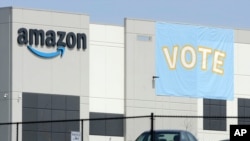 FILE - In this Tuesday, March 30, 2021 file photo, a banner encouraging workers to vote in labor balloting is shown at an Amazon warehouse in Bessemer, Ala. Amazon workers voted against forming a union, Friday, April 9, in Alabama, handing the…