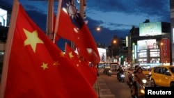 FILE - Flags of China and Taiwan flutter next to each other during a rally calling for peaceful reunification, days before the inauguration ceremony of President Tsai Ing-wen, in Taipei, Taiwan, May 14, 2016. 