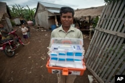 FILE - A village malaria worker shows his malaria medicine kit at O'treng village on the outskirts of Pailin, Cambodia, Aug. 29, 2009.