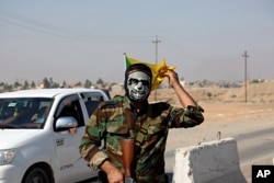 A fighter with Popular Mobilization Forces stands guard in Tuz Khormato, 130 miles (210 kilometers) north of Baghdad, Iraq, Oct. 16, 2017.