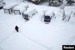 A man walks in the snow ahead of the World Economic Forum (WEF) annual meeting in the Swiss Alps resort of Davos, Switzerland, Jan. 21, 2018