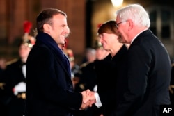 French President Emmanuel Macron, and his wife, Brigitte Macron, obscured, welcome German President Frank-Walter Steinmeier and his wife in front of Notre-Dame cathedral in Strasbourg, France, as part of the celebrations of the centenary of World War I.