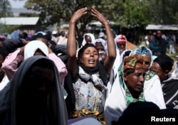 FILE - Women mourn during the funeral ceremony of Dinka Chala, a primary school teacher who family members said was shot dead by military forces during a recent demonstration, in Holonkomi town, in Oromia region of Ethiopia, Dec. 17, 2015.