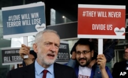 Britain's leader of the opposition Labour Party Jeremy Corbyn speaks to the media alongside demonstrators from multi-faith group 'Turn to Love' holding a vigil at New Zealand House in London, March 15, 2019.