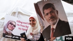 Activist in Cairo carries a sign that says: "Wait! Don't kill me. I'm not terrorist. I''m not even with the Muslim Brotherhood. I'm an Egyptian who loves my country. I'm a Muslim who loves my religion," Aug 2, 2013. (Hamada Elrasam for VOA)