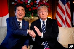 FILE - President Donald Trump and Japanese Prime Minister Shinzo Abe speak during a meeting at Trump's private Mar-a-Lago club, in Palm Beach, Fla.