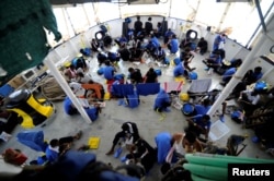 FILE - Migrants are seen on board the MV Aquarius, in the Mediterranean Sea, between Malta and Linosa, Aug. 14, 2018.