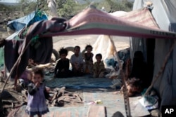 FILE - Displaced children sit in their family's tent at a camp for internally displaced people in the outskirts of Sana'a, Yemen, June 8, 2016.