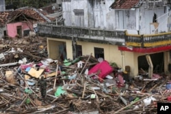An Indonesian soldier inspects the damage at a tsunami-ravaged village in Sumur, Dec. 25, 2018.