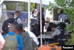 FILE - Refugees are processed by the Royal Canadian Mounted Police (RCMP) after crossing illegally into Canada at the U.S.-Canada border on Roxham Road from Champlain, New York, August 3, 2017.