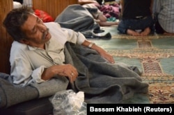 FILE – A survivor of what activists say was a gas attack rests in a mosque in Damascus’ Duma neighborhood, Aug. 21, 2013.