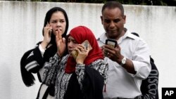 People wait outside a mosque in central Christchurch, New Zealand, March 15, 2019.