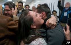FILE - Family members who have just arrived from Syria embrace and are greeted by family who live in the United States upon their arrival at John F. Kennedy International Airport in New York, Feb. 6, 2017.