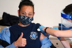 Seorang pekerja dari Biro Layanan Darurat Medis, Departemen Pemadam Kebakaran Kota New York, menerima vaksinasi vaksin Covid-19 buatan Moderna, di Manhattan, Kota New York, New York, Rabu, 23 Desember 2020. (Foto: Carlo Allegri/Reuters)