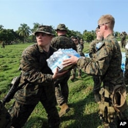 U.S. Marines load a U.N. truck with water to be distributed among Haitian earthquake survivors in Leogane, 20 Jan 2010