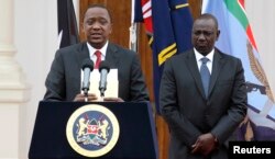 FILE - Kenyan President Uhuru Kenyatta, left, with Deputy President William Ruto, addresses reporters at the State House in Nairobi, Dec. 2, 2014.