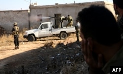 Fighters from the Free Syrian Army fire a machine gun mounted on a vehicle deployed during fighting against Islamic State group jihadists on the outskirts of the northern Syrian town of Dabiq, Oct. 15, 2016.