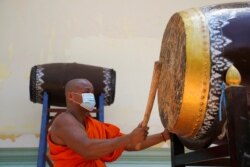 Seorang biksu memukul beduk setelah PM Kamboja Hun Sen memerintahkan agar semua pagoda membunyikan lonceng dan beduk lima kali sehari sebagai pesan untuk melawan COVID-19, di Phnom Penh, Kamboja, 24 Maret 2021. (Foto: REUTERS/Cindy Liu)
