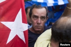 A supporter of the Ladies in White dissident group looks on as he is detained by Cuban security personnel during a protest on International Human Rights Day, Havana, December 10, 2015.