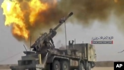 FILE - Photo taken from video provided by the government-controlled Syrian Central Military Media shows firing on militants' positions on the Iraq-Syria border, Nov 8, 2017. The Britain-based Syrian Observatory for Human Rights said Islamic State militants have withdrawn from their last stronghold following a government offensive.