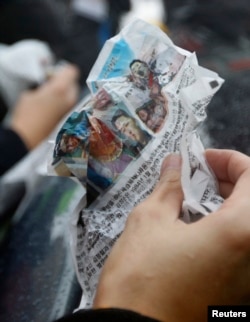FILE - A journalist holds an anti-Pyongyang leaflet.