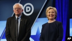 FILE - Democratic presidential candidates Hillary Clinton, right and Sen. Bernie Sanders stand together before the start of a Democratic presidential debate at Miami-Dade College, in Miami, Fla., March 9, 2016. Even though he is trailing Clinton in delegates, Sanders has pledged to stay in the primary race.