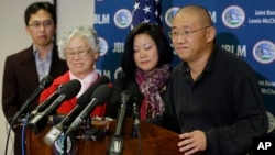 FILE - Family members watch as Kenneth Bae, right, freed during a top-secret mission, talks to reporters after he arrived at Joint Base Lewis-McChord, Washington, Nov. 8, 2014.