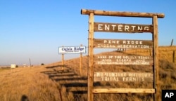 FILE - This Sept. 9, 2012 file photo shows the entrance to the Pine Ridge Indian Reservation in South Dakota, home to the Oglala Lakota tribe.
