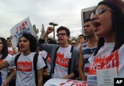 FILE - Youth from United We Dream chant slogans calling for an end to deportations outside the Immigration and Customs Enforcement (ICE) offices in downtown Phoenix, Feb. 22, 2014.