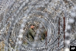 FILE - Georgian border guards patrol a border with Georgia's breakaway region of South Ossetia, near the village of Khurvaleti, Georgia, April 8, 2017.
