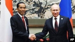 Presiden Rusia Vladimir Putin (kanan) menjabat tangan Presiden Joko Widodo dalam pertemuan forum Kerja Sama Ekonomi Asia Pasifik (APEC) di Beijing, pada 10 November 2014. (Foto: AP)