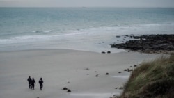 FILE- French police officers patrol on the beach in search of migrants in Wimereux, northern France, Nov.17, 2021.