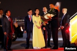 U.S. President Barack Obama receives flowers as he arrives at Noibai International Airport in Hanoi, Vietnam, May 22, 2016.