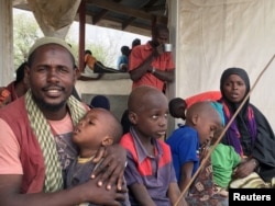 FILE - A Somali family waits to board a bus that will take them back home to Somalia from the Dadaab refugee camp in a voluntary repatriation programme, in Kenya, Jan. 21, 2016.
