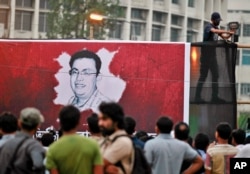 FILE - A Bangladeshi activist sets up a light on a poster displaying a portrait of slain Bangladeshi-American blogger Avijit Roy in Dhaka, Bangladesh, Feb. 27, 2015.