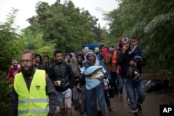 Migrants walk towards Serbia's border with Croatia in Berkasovo, Serbia, Sept. 27, 2015.