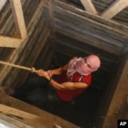 A Palestinian smuggler uses a rope to climb out of a tunnel linking the southern Gaza Strip town of Rafah with Egypt (File)