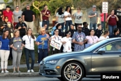 Local residents show their support as students arrive at Marjory Stoneman Douglas High School for the first time since the mass shooting in Parkland, Florida, Feb. 28, 2018.