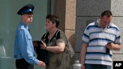 People smoke outside a shopping mall in downtown Moscow, Russia, June 1, 2013.