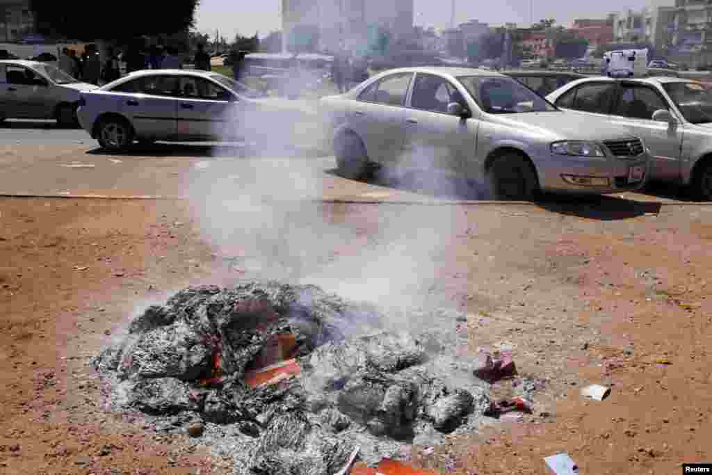 Used ballot booklets, which were set on fire by anti-election protesters, are seen in a square in central Benghazi, Libya, July 7, 2012. 